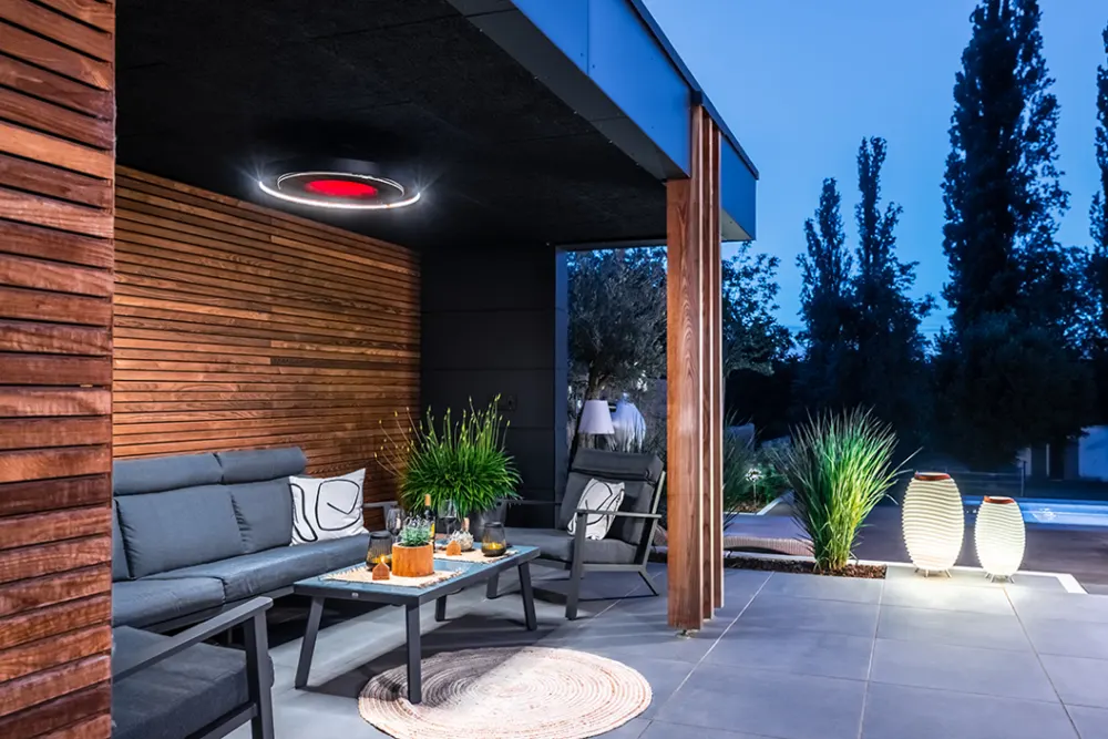 Chauffage de terrasse Bromic Eclipse au-dessus d'un salon extérieur en soirée